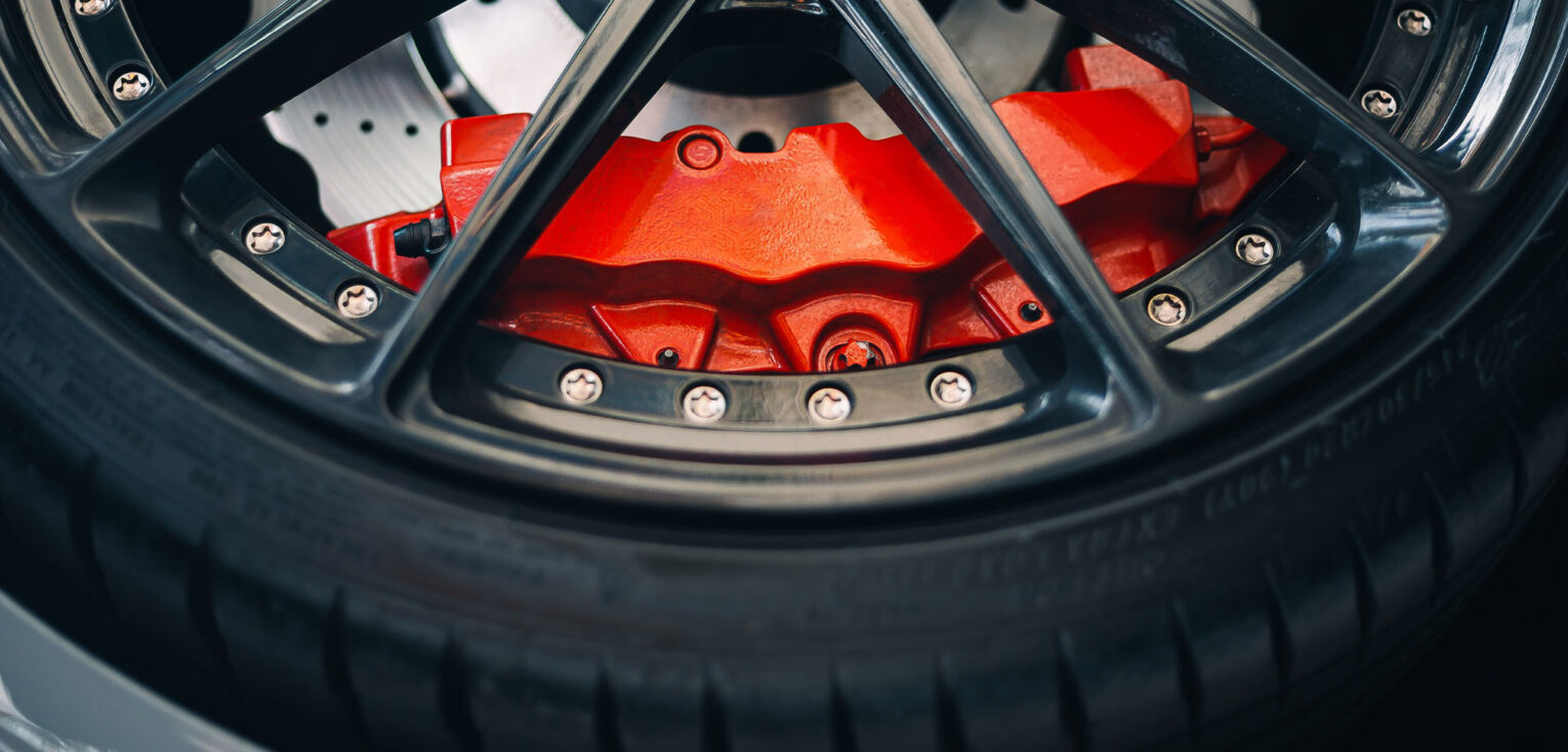 Photo of part of a tire and a red brake showing through