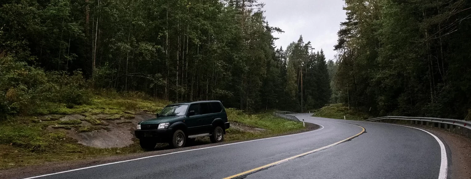 An overheated car sitting on the side of the road