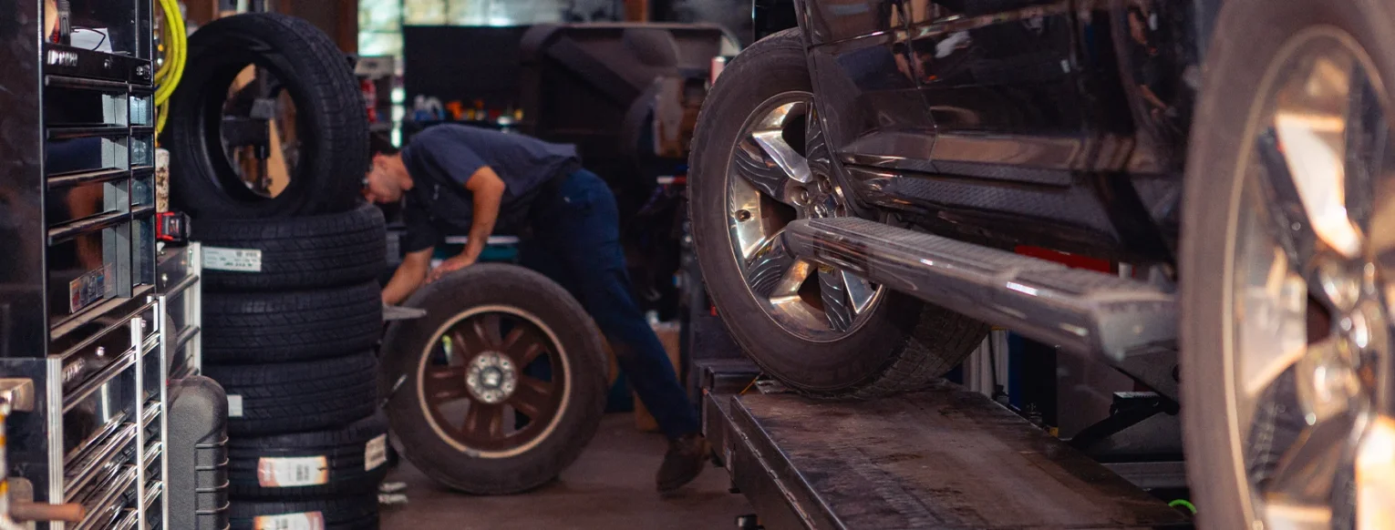 A Restored Auto employee performing a tire rotation