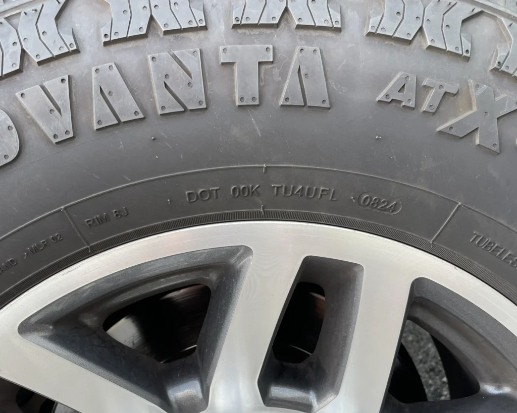 A photo of a tire with a DOT designation that says "DOT 00K TU4UFL 0824"