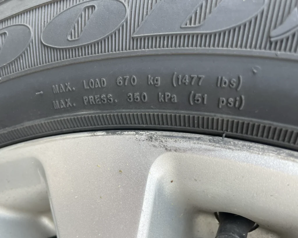 A photo of a tire with a max load and air pressure code. It says, "MAX LOAD 670 kg (1477 lbs)" and "MAX PRESS 350 kPa (51 psi)"