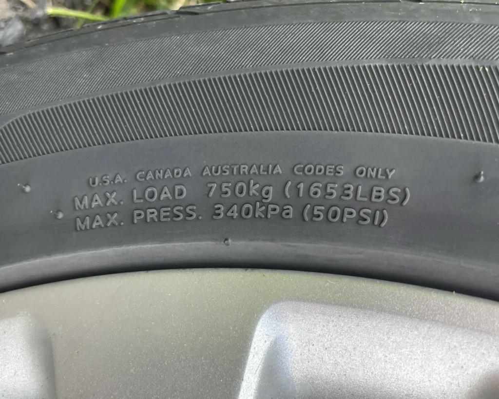 A photo of a tire with a tire with max load and max air pressure codes that say, "MAX LOAD 750 kg (1653 LBS)" and "MAX PRESS. 340 kPa (50 PSI)"