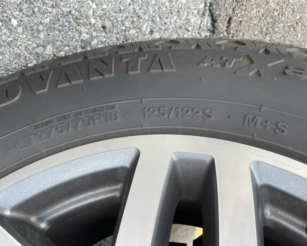 A photo of a tire with a tire code that says, "LT 275/70 R 18 125/122S M+S"