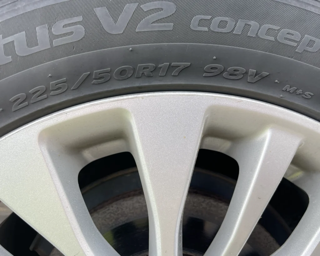 A photo of a tire with a tire code that says, "225/50 R 17 98V M+S"