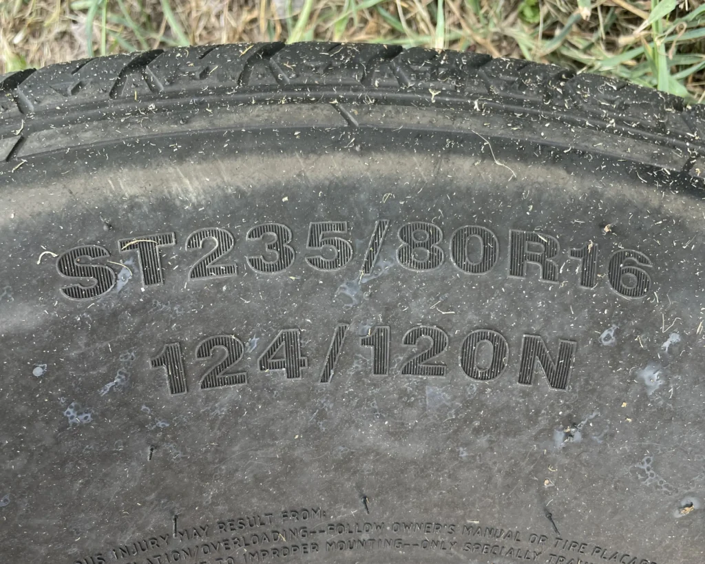 A photo of a tire with a tire code that says, "ST 235/80 R 16 124/120 N"