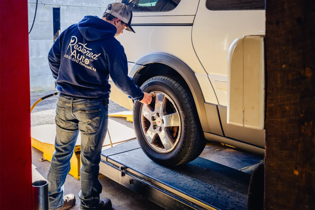 A Restored Auto mechanic working on a tire